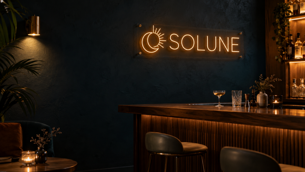 Enseigne néon LED sur mesure - SOLUNE Enseigne néon LED SOLUNE et logo lumineux au-dessus d’un comptoir de bar