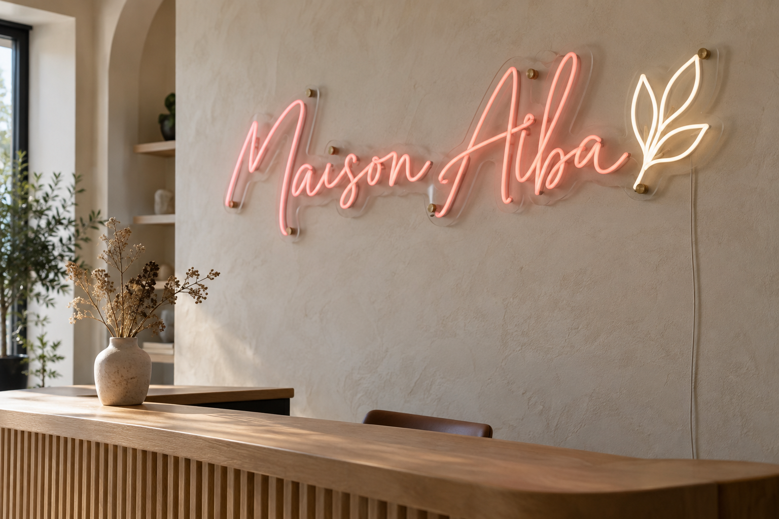 Néon LED rose Maison Alba et logo feuille lumineux sur un mur d’accueil